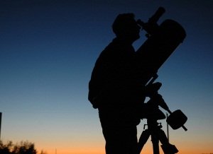 a man watching the stars through a telescope